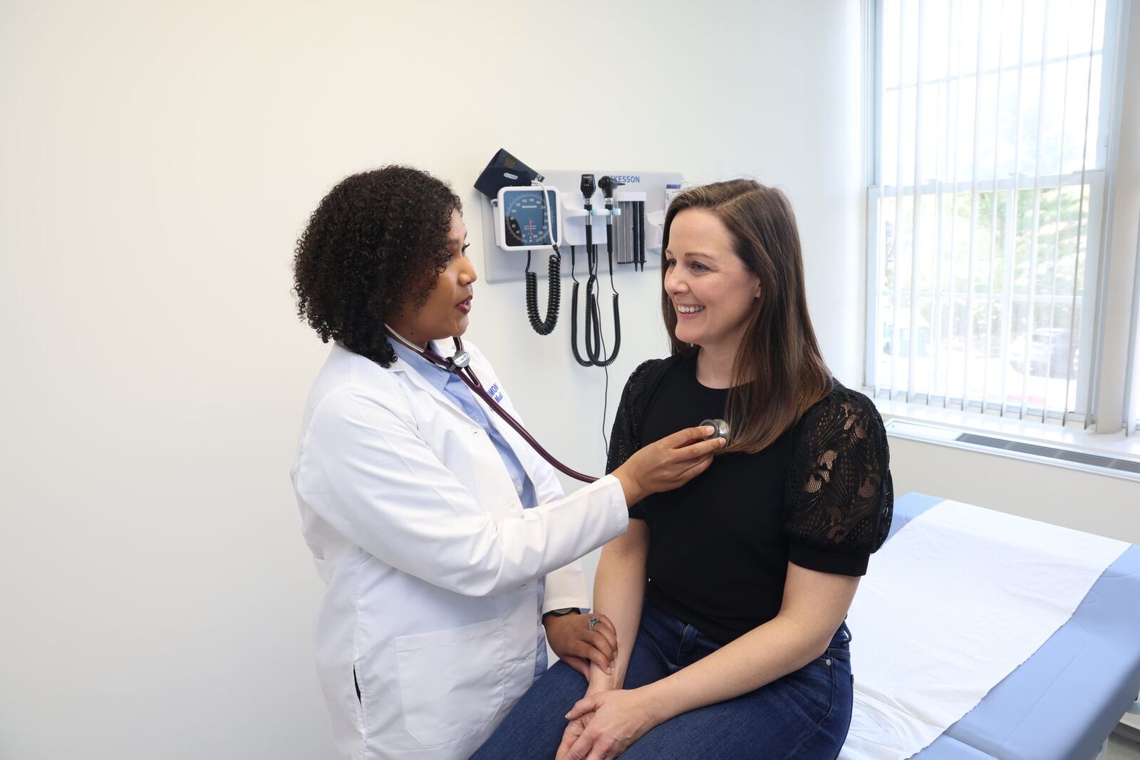 Dr. Ruth Solomon listening to a patient in the exam room